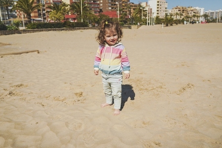 Young toddler playing with the sand at the beach
