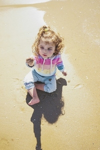 Mid section of a little girl playing at the seashore