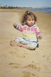 Little girl having meditation time at the beach