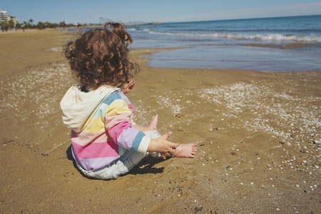 Mid section of a little girl playing at the seashore