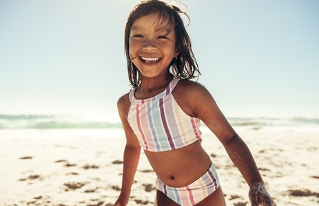 Adorable little girl having fun at the beach