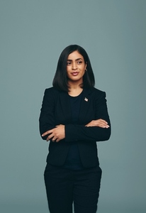 Pensive congresswoman standing with her arms crosed in a studio