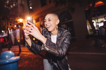 Happy young woman taking pictures with a smartphone