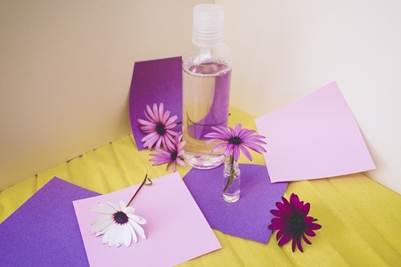 Still life of eco cosmetics with flowers in paper background des
