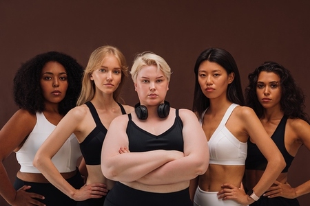 Five confident women in sportswear standing together  Females of different body types looking at camera
