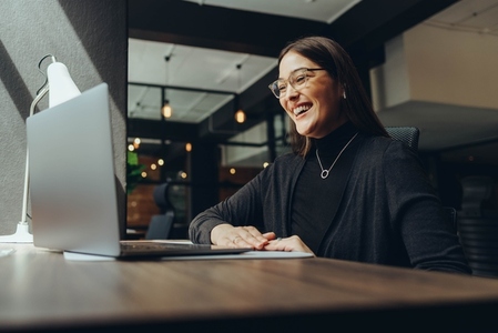 Smiling businesswoman attending an online meeting in a coworking office
