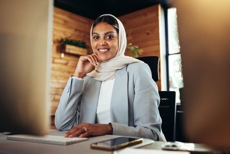 Happy Muslim businesswoman working in a modern office