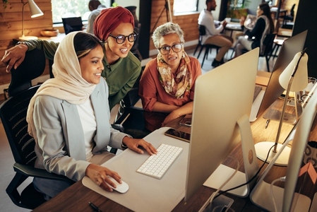 Happy businesswomen working together on a computer