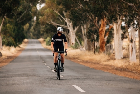 Woman standing out of the saddle on road bike while riding  Pro cyclist exercising on empty road