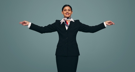 Air hostess mimicking and airplane in a studio