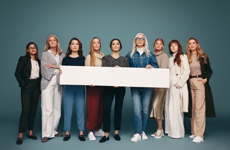 Feminist activists holding a white banner in a studio