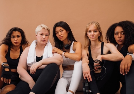 Five confident females in sportswear with fitness accessories  Group of young sports women of different ethnicities looking at camera