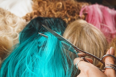 Hairdresser cutting a blue wig to stylize it