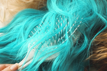 Close up of a brush brushing a colored wig