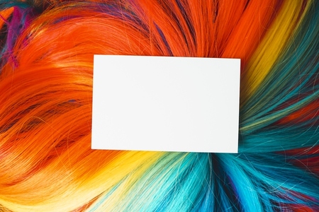 Mockup of a white business card over a multicolored wig