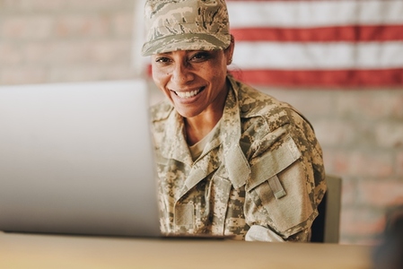Patriotic female soldier video chatting with her family on a laptop