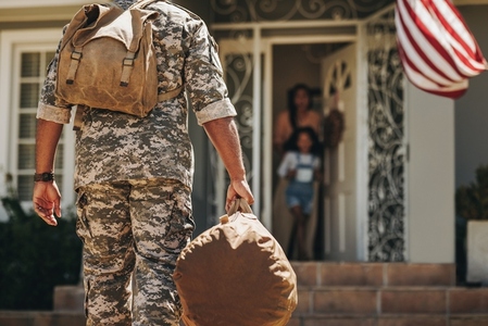 Rearview of a soldier returning home to his family