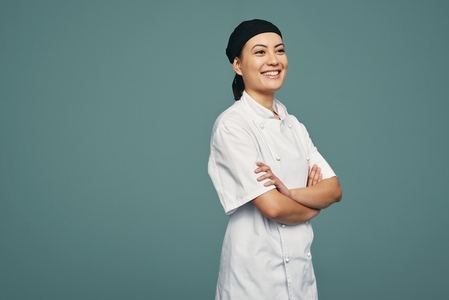 Happy female chef smiling cheerfully in a studio