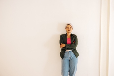Businesswoman standing against a wall in a modern office