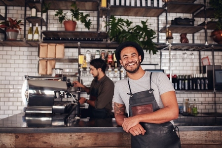 Coffee shop worker smiling to camera