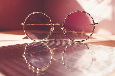 Studio shot of trendy female sunglasses in coral tones for summe