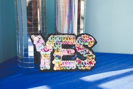 Colorful word yes in a retro disco background