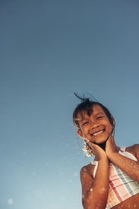Cheerful little girl having fun on a beach day