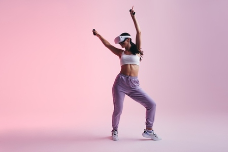 Cheerful young woman dancing in virtual reality