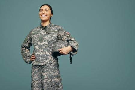 Cheerful female soldier smiling in a studio