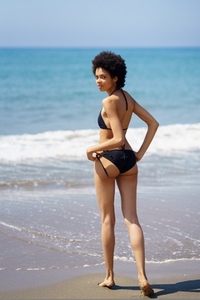 Rear view of black girl with slim body wearing bikini on a tropical beach
