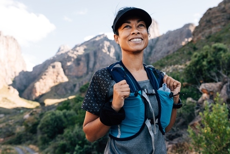 Portrait of positive woman hiker standing in valley  Young female enjoying the hike