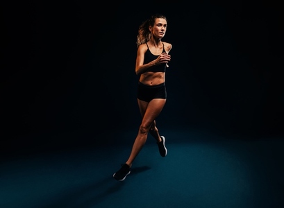 Female runner exercising on black background  Woman jogging and