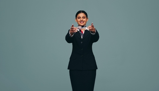 Flight attendant pointing at the camera in a studio