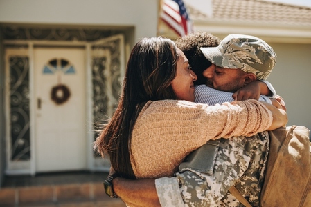 Military serviceman reuniting with his family at home