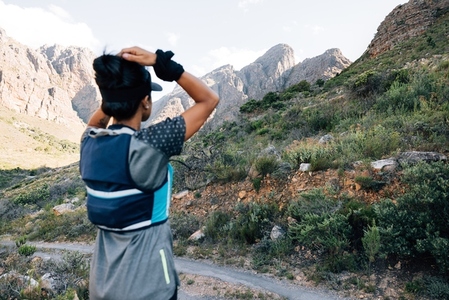 Back view of woman hiker looking in valley and enjoying the view  focus on mountains