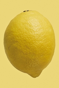 Close up dimples on vibrant whole yellow lemon