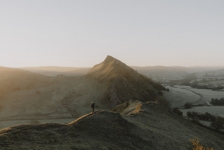 Man hiking on hill ridge in tranquil rural landscape at sunrise