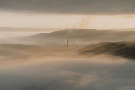 Smokestack in tranquil sunny foggy landscape at sunrise 1