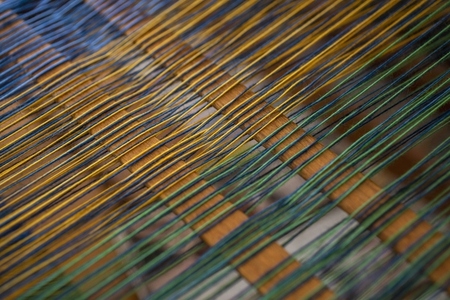 Close up green and yellow thread on loom