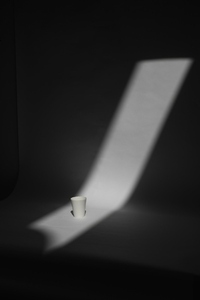 Disposable paper cup in strip of white light