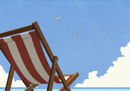 Seagulls flying in summer blue sky over striped beach chair