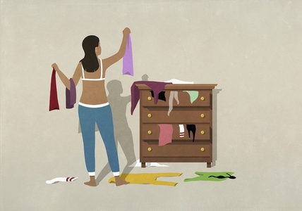 Woman getting dressed at messy bedroom dresser