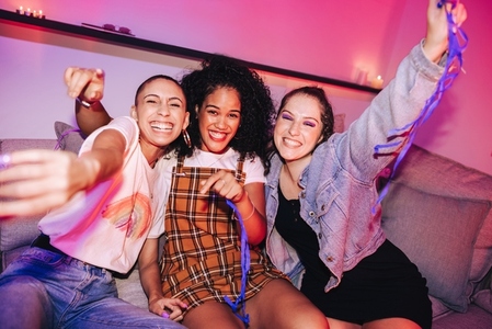 Three girlfriends having a good time at a house party