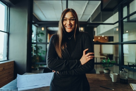 Cheerful young businesswoman smiling with her arms crossed