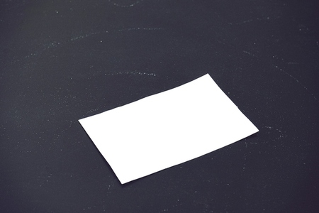 Simple mockup of a white business card against black blackboard