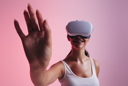 Cheerful young woman touching virtual space with her hands