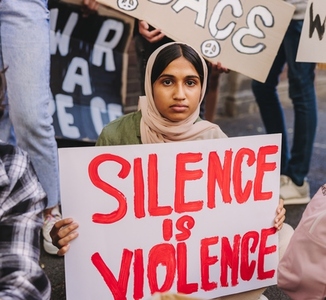 Muslim girl holding an anti violence poster