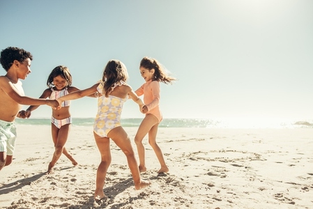 Energetic little kids playing a game together at the beach