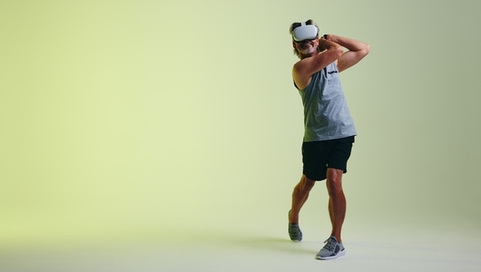 Happy senior man golfing in virtual reality
