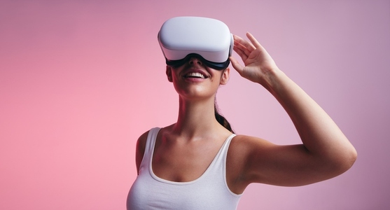 Happy young woman wearing virtual reality goggles